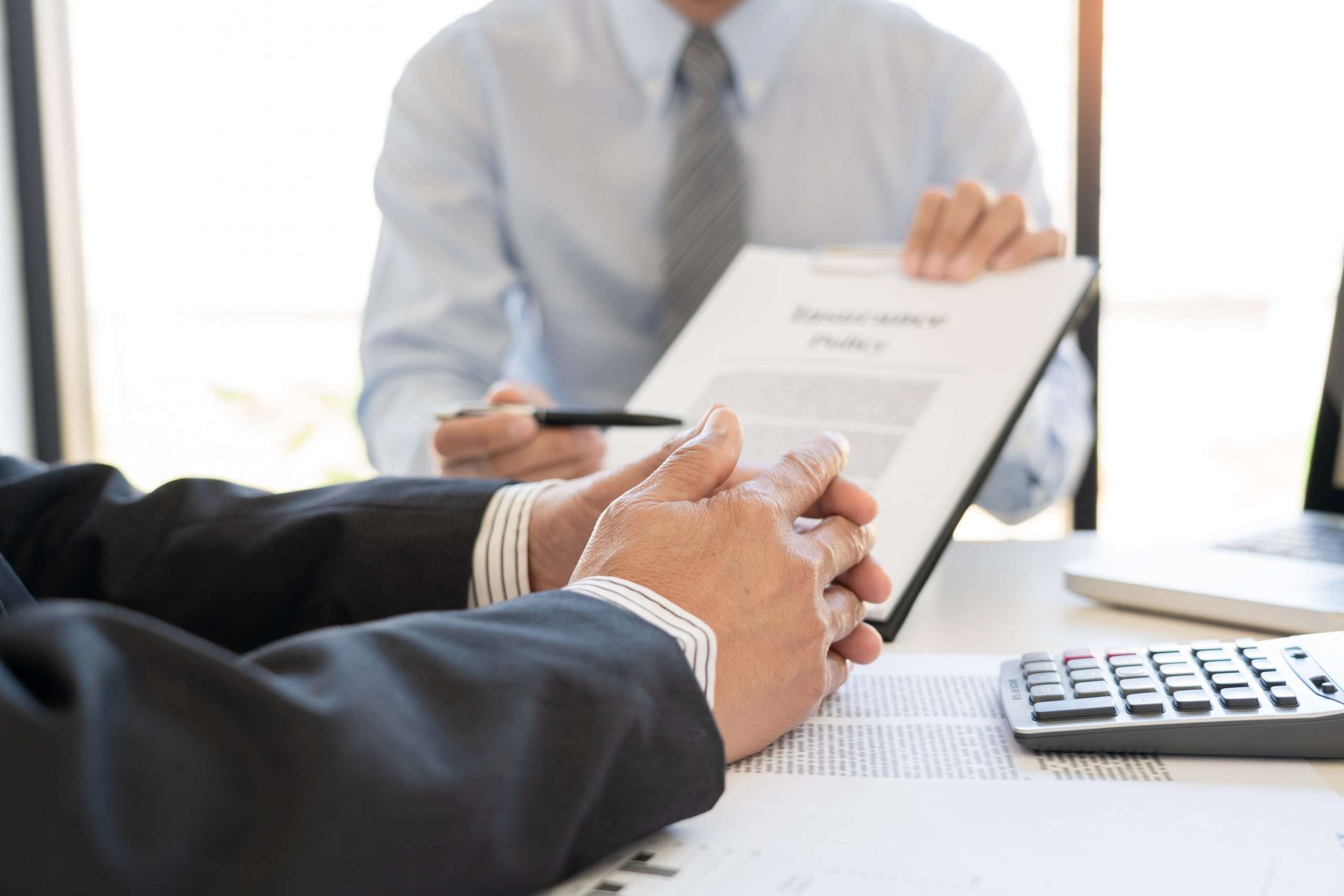 Confident cyber insurance agent broker man holding document and present pointing showing an insurance policy contract form to client Business Communication Connection Concept understanding a cyber insurance policy